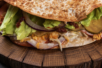 Pita with fresh vegetables and meat on a wooden tray