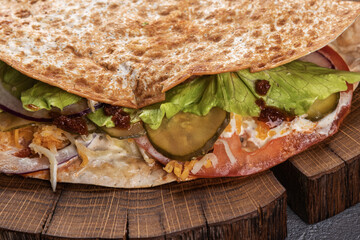 Pita with fresh vegetables and meat on a wooden tray