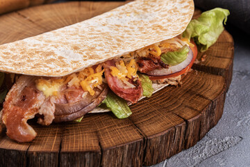 Pita with fresh vegetables and meat on a wooden tray