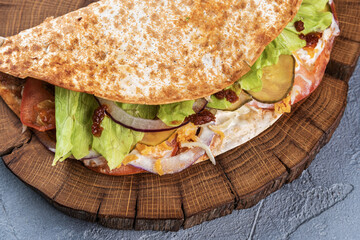 Pita with fresh vegetables and meat on a wooden tray