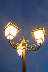 Leuchtende Straßen Laternen vor einem blauen Himmel