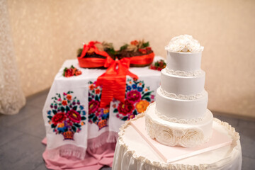 White Wedding Cake on Table With Embroidered Tablecloth