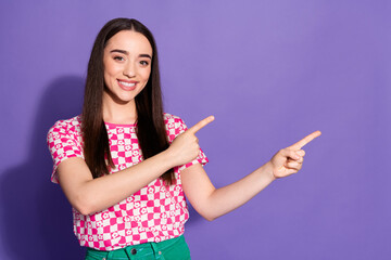 Portrait of nice young woman direct fingers empty space wear checkered t-shirt isolated on violet color background