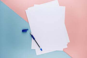 Blue Pen and White A4 Paper on Pink and Textured Blue Background - Stationery Setup. High quality photo