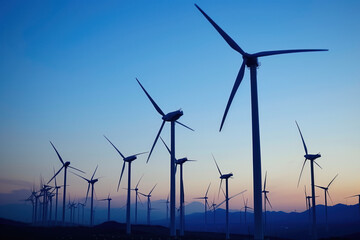 Green energy: wind turbines against sunset background