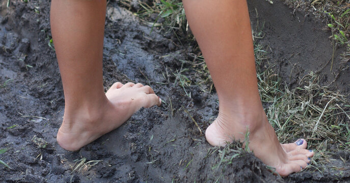 Girl barefoot leg on mud. - Powered by Adobe