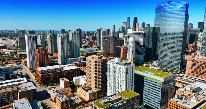 Flying above the modern Chicago, IL, the USA. Sunny view of metropolis buildings from drone.