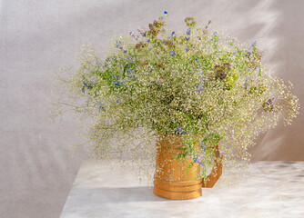 Bouquet of wildflowers on a gray background in sunlight