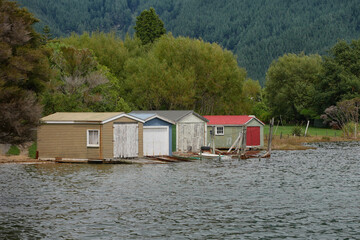 Weathered boathouses beside a lake