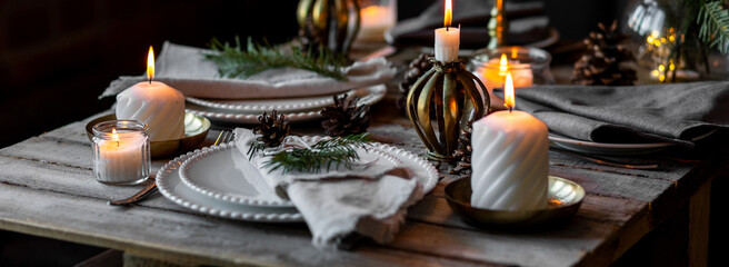 Banner. Elegant decor for Christmas family dinner. Center piece with burning candles, vintage chandelier. Zero waste eco-friendly home decoration, fir tree branches. Cozy atmosphere, wooden furniture