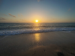 A empty beach, waves and a beautiful sunset.