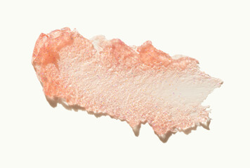 Cosmetic glittering lip balm or scrub orange swatch isolated on beige
