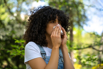 Curly-haired young woman suffering from seasonal allergy