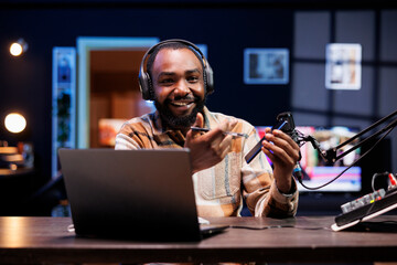 Cheerful tech expert going on-air, describing details of new mobile device for online viewers....