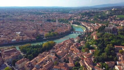 Aerial view of Verona, Italy, showcasing the Adige River winding through the city with historic buildings.