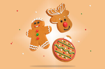 Tasty Christmas cookies of different shapes and sprinkles in air on beige background