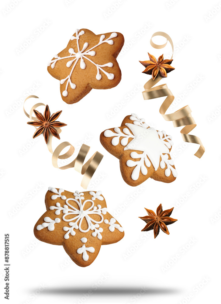 Wall mural tasty christmas cookies, anise stars and golden streamers in air on white background