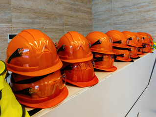 Stacks of orange safety construction helmets