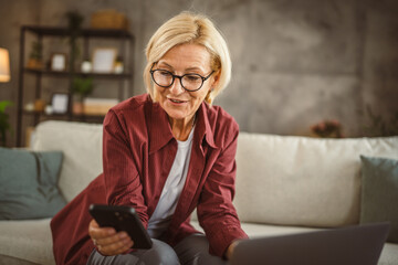 Obraz premium Mature senior woman work from home and use mobile phone on break