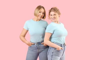 Beautiful happy women in stylish jeans on pink background