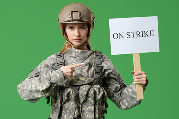 Protesting female soldier pointing at placard with text ON STRIKE against green background