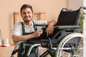 Male worker with wrench repairing wheelchair in room