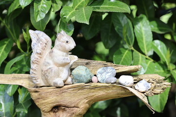 little squirrel decoration and stones on a tree stump