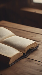 An open book sits atop a wooden table ready for reading