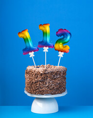Air balloon number 112 - Birthday cake on blue background