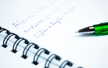 Fototapeta premium An algebraic equation on a notepad with a pen. Mathematical calculations written in a notebook.