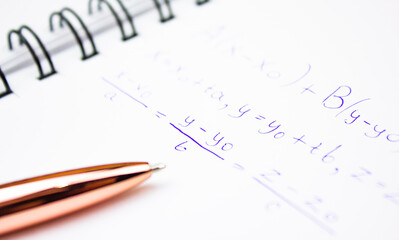 An algebraic equation on a notepad with a pen. Mathematical calculations written in a notebook.
