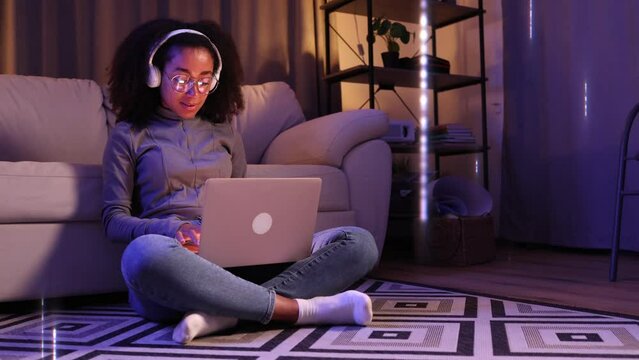 A woman sitting on the floor, using a laptop to connect to the global network