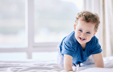 Fototapeta premium Baby, happy and crawl on bed for learning, moving and motor skills with growth in morning at family house. Infant, smile and development on sheets in bedroom with play, progress and excited in home