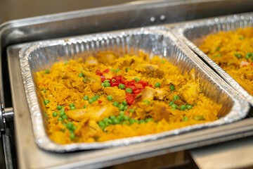 Yellow rice in a silver pan, rice catering at an event in a serving container. 