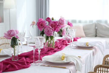 Beautiful table setting with pink peonies in dining room