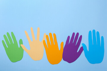 Obraz premium Equality concept. Different paper palms on light blue background, flat lay. Space for text
