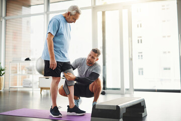 Senior, man and physiotherapist with knee bandage for support, circulation or compression for...