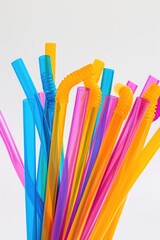 A collection of plastic drinking straws placed in a clear glass container