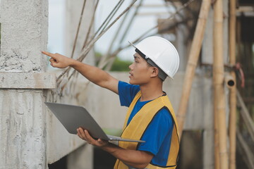 Young handsome asian civil engineer holding tablet looking forward and thinking, planning on construction building background. Evolution construction concept.