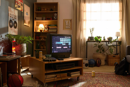 Retro gaming setup with old-fashioned TV, gaming console, and nostalgic decor in cozy living room with no people