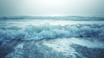 Fototapeta premium A wave breaks on the sandy beach at sunset