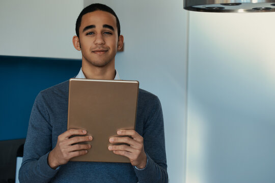 Young man smiling holding digital tablet at home in kitchen - Powered by Adobe