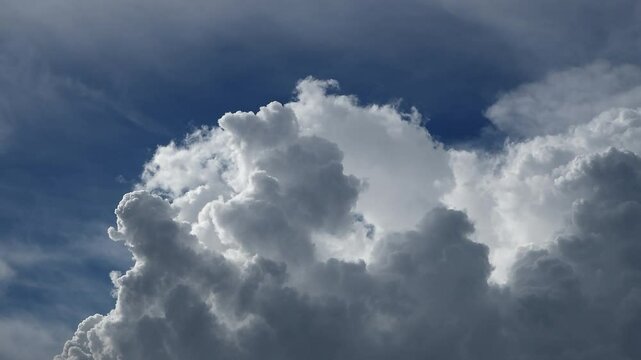 Dramatic time-lapse of cloudscapes transform across a bright blue sky in the ever-changing nature of the weather