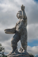 Fototapeta premium a statue of a boy holding the sky