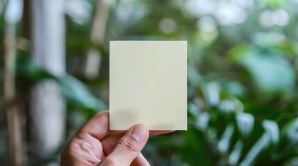 Sticky note being held on white surface