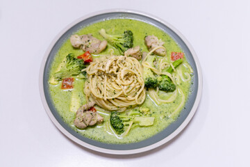 delicious pesto pasta, featuring a rich, green basil pesto sauce. The dish is beautifully presented with fresh ingredients, offering a flavorful and savory experience