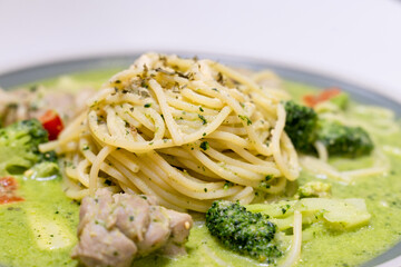 delicious pesto pasta, featuring a rich, green basil pesto sauce. The dish is beautifully presented with fresh ingredients, offering a flavorful and savory experience