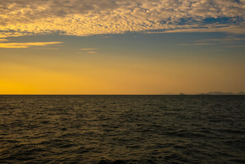 Fototapeta premium Panoramic views of the skyline The sun sets in the evening sky with colorful clouds. and beautiful cloud patterns In the soft light of the evening at sea