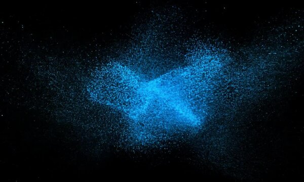 Blue powder explosion against a black background, creating a vibrant and dynamic abstract pattern