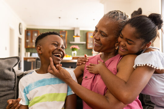 Senior African American woman enjoys a playful moment at home with grandchildren